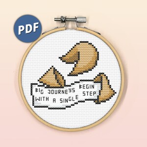 May include: A cross-stitch pattern featuring three fortune cookies with the text "Big journeys begin with a single step".