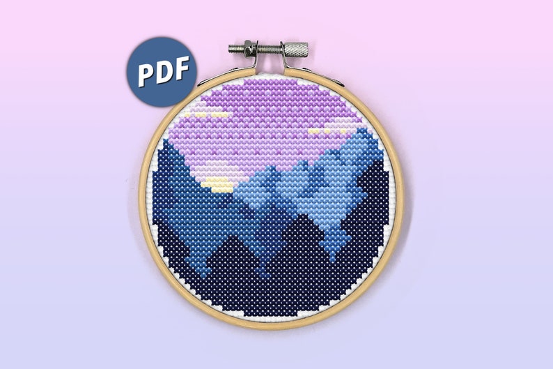 Puede incluir: Un bastidor de bordado circular de madera que contiene un patr&oacute;n de punto de cruz de un cielo nocturno azul oscuro con una luna morada grande y texturizada y nubes de color amarillo claro. Un icono azul con el texto blanco PDF est&aacute; arriba a la izquierda.