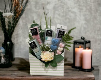May include: A green and white striped envelope box filled with scented wax melts, a bouquet of white and green flowers, and heart-shaped wax melts. The box is decorated with a white rose and green leaves.