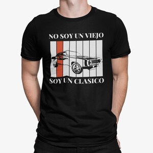 May include: Black t-shirt with white text that reads "NO SOY UN VIEJO SOY UN CLASICO". The text is framed by a red and white striped background with a black and white silhouette of a classic car.