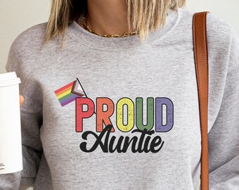 May include: Gray sweatshirt with the text "PROUD Auntie" in rainbow colors and a rainbow pride flag graphic.