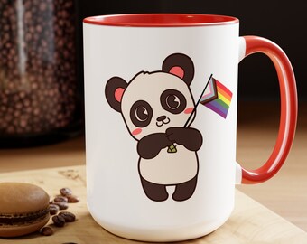 May include: White ceramic mug with a red rim and handle. The mug features a cartoon panda holding a rainbow pride flag.