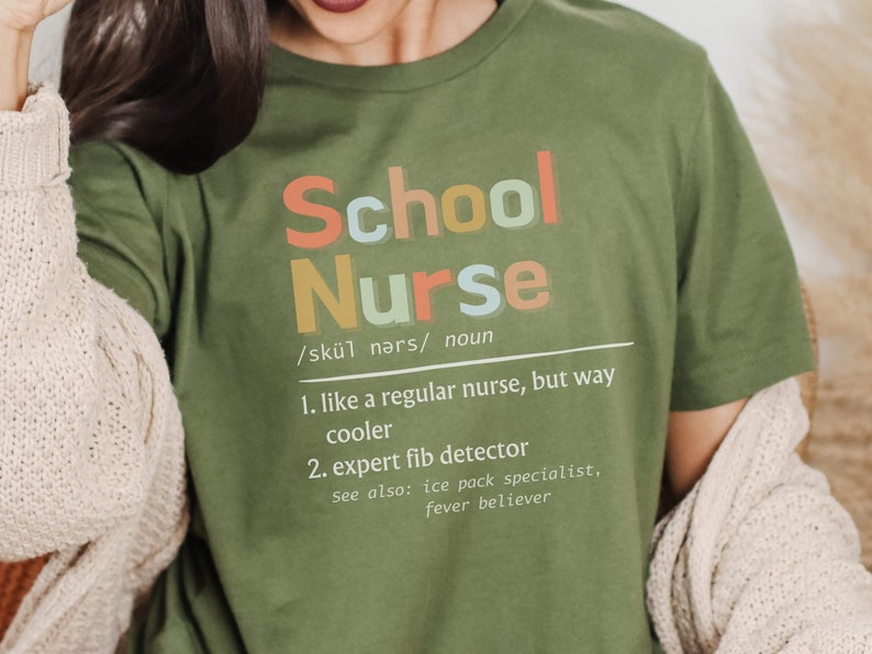 Peut inclure: T-shirt vert avec le texte "School Nurse" d&eacute;fini comme "comme une infirmi&egrave;re ordinaire, mais bien plus cool" et "d&eacute;tecteur de mensonges expert".