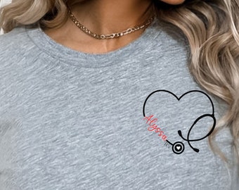 May include: A gray t-shirt with a black and red graphic of a stethoscope inside a heart with the word "Alyssa" written inside the heart.