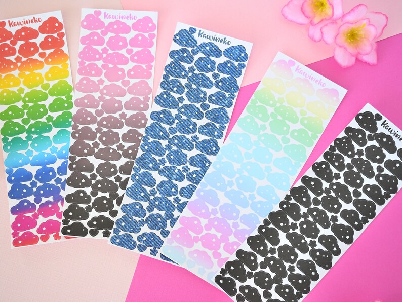 May include: Six sheets of cloud stickers with different color gradients and patterns. The stickers feature a cloud design with white stars. The sheets are labeled "Kawineko".