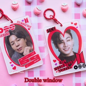 Puede incluir: Dos llaveros de acrílico transparente con detalles rojos. Cada llavero presenta una foto de una persona, con el texto "BTS WORLD TOUR ARIRANG" y "ARMY". Los llaveros están decorados con corazones y un cierre rojo.