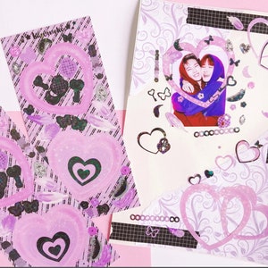 May include: A pink and purple scrapbook page featuring a photograph of two people smiling and hugging. The page is decorated with hearts, butterflies, and other embellishments. The text "Love you" is written on the page.
