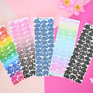 May include: Five sheets of cloud-shaped stickers with different patterns. The stickers are arranged in a row from left to right. The patterns are rainbow, pink and gray, blue denim, light blue and pink, and black. Each sheet has the word "Kawaiiho" printed on it.