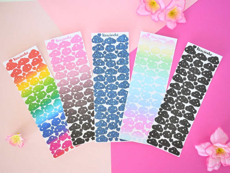 May include: Five sheets of cloud-shaped stickers with different patterns. The stickers are arranged in a row from left to right. The patterns are rainbow, pink and gray, blue denim, light blue and pink, and black. Each sheet has the word "Kawaiiho" printed on it.