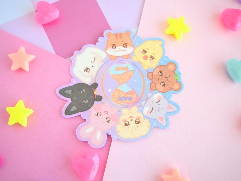 Op de afbeelding: Een set van acht kleurrijke dieren stickers met een kat, een konijn, een hond, een hamster, een vogel, een vos, een beer en een zeemeermin. De stickers zijn in een cirkel rond een zandloper met de woorden "Peace" en "Love" erop gerangschikt.