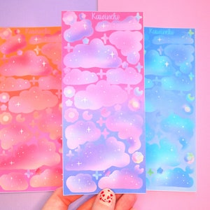 May include: Three sheets of colorful cloud stickers with a gradient background. The stickers are pink, purple, and blue with white stars and clouds. The text "Kawaii.nko" is printed on each sheet.