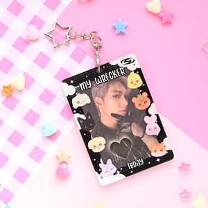May include: A clear plastic ID card with a photo of a person, surrounded by cartoon animal and cloud graphics. The card has the text "my WRECKER TODAY" and is attached to a silver star-shaped keychain.