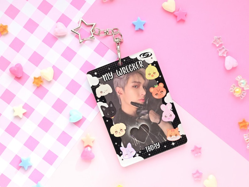 May include: A clear plastic ID card with a photo of a person, surrounded by cartoon animal and cloud graphics. The card has the text "my WRECKER TODAY" and is attached to a silver star-shaped keychain.