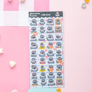 Op de afbeelding: Een stickervel met cartoon luiaards met zonnebrillen. De luiaards worden in verschillende poses afgebeeld, sommige houden harten of cadeaus vast. Het vel heeft een rasterpatroon en de tekst "Little crow" en "@caunekoshop" is zichtbaar.