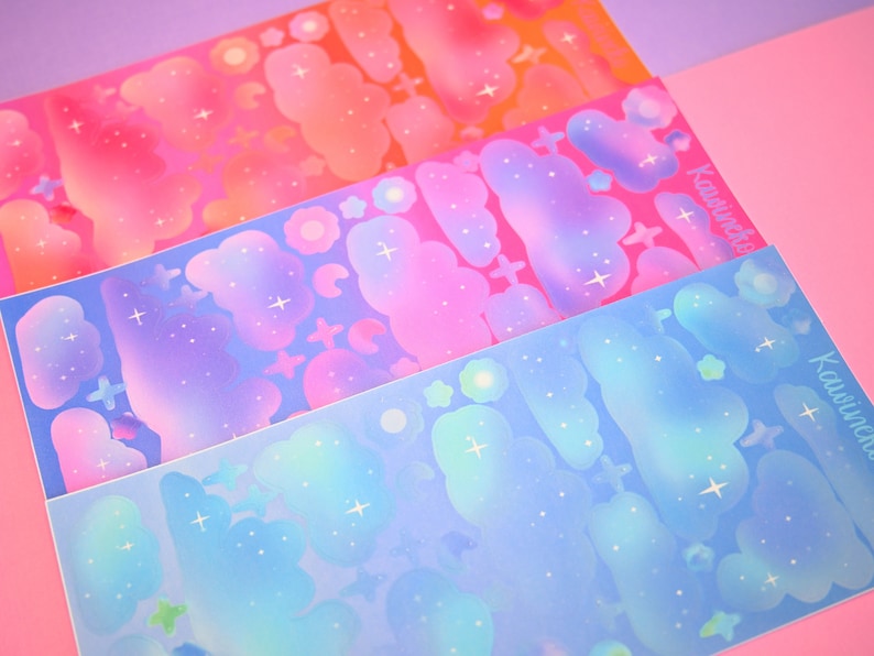 May include: Three sheets of iridescent holographic stickers featuring clouds and stars in shades of pink, blue, and orange. The stickers are labeled "Kawaiiverse".