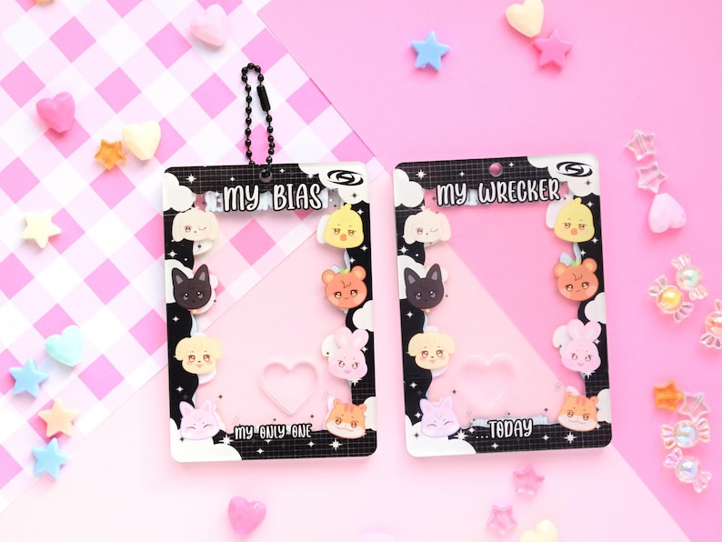 May include: Two clear plastic card holders with black and white borders, featuring cartoon animal designs. The text "MY BIAS" and "MY WRECKER" are displayed. The background is pink with decorative candies.