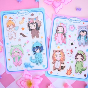 May include: Two sheets of stickers featuring characters from the anime Demon Slayer in various animal costumes. The stickers are on a pink and blue background with stars and hearts. The text "KawaiiNeko" is printed on both sheets.