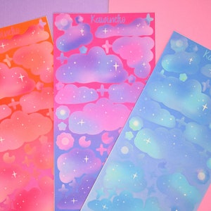 May include: Three sheets of colorful stickers with a cloud and star design. The sheets are pink, blue, and orange. The stickers are labeled "Kawineko".