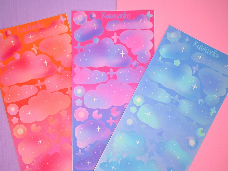 May include: Three sheets of colorful stickers with a cloud and star design. The sheets are pink, blue, and orange. The stickers are labeled "Kawineko".