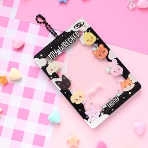 May include: A black and white rectangular photo frame with the text "MY WRECKER" and "TODAY". The frame is decorated with cartoon animal faces and is surrounded by pink and white candies and stars.