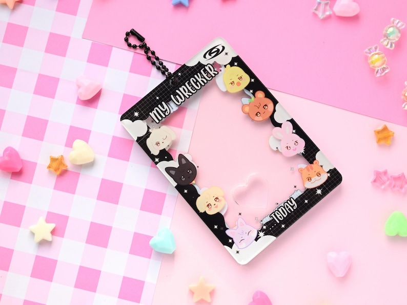 May include: A black and white rectangular photo frame with the text "MY WRECKER" and "TODAY". The frame is decorated with cartoon animal faces and is surrounded by pink and white candies and stars.