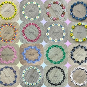 May include: A collection of sixteen beaded bracelets arranged in a grid, each featuring a flower pattern with unique color combinations labeled with names including Sunflower, Willow, Riley, Taylor, Sprinkles, Barbie, Blossom, Georgia, Cherry Blossom, Mabel, Lucky, Genesis, Aurora, Daisy, Raven, and Hannah.