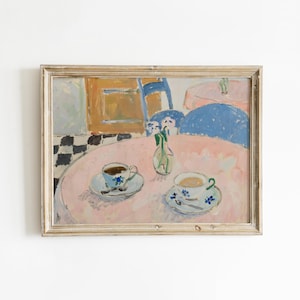 May include: A framed painting depicting a round pink table with two teacups on saucers and a small glass vase with flowers. The scene includes a blue chair, a checkered floor pattern, and a soft color palette of pink, blue, and white brushstrokes.
