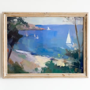 May include: A framed oil painting depicting a seascape with sailboats on a blue body of water. The painting is framed in a light wood frame.
