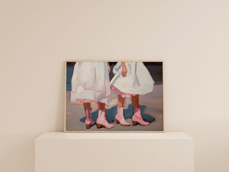 May include: Painting of two people wearing white dresses and pink boots. The painting is framed in a wooden frame.