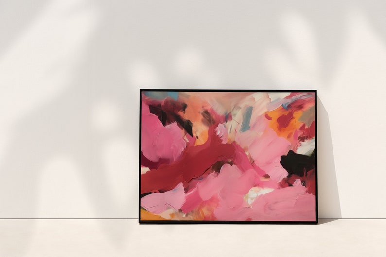 May include: Abstract art print in a black frame. The artwork features a vibrant mix of colors, including shades of pink, red, orange, and black. The brushstrokes create a dynamic and textured appearance, suitable for home decor.