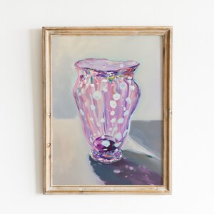 May include: A painting of a pink and white polka dot vase with a purple base. The vase is in a wooden frame.