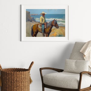 Pu&ograve; includere: Stampa artistica incorniciata di un cowboy a cavallo sulla spiaggia. L'opera presenta un uomo con cappello da cowboy e camicia gialla, in sella a un cavallo marrone. Lo sfondo mostra l'oceano e le scogliere, con un cielo blu.