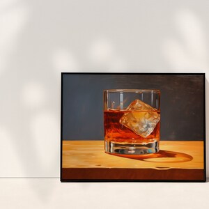 May include: A framed painting of a glass of amber liquid with a large ice cube, sitting on a wooden surface.