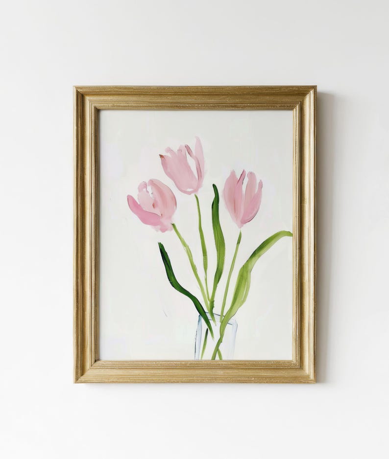 May include: A framed watercolor painting of three pink tulips in a clear glass vase. The tulips are painted in a loose, abstract style with soft, flowing lines. The background is a simple white.