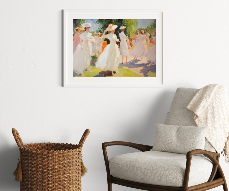 May include: A framed art print depicts a sunny outdoor scene of people in white dresses and hats. The impressionistic painting has a soft color palette of white, pink, green, and yellow. The artwork is displayed on a white wall above a chair and basket.