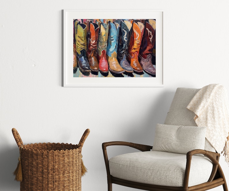 May include: A framed wall art print featuring a colorful painting of a row of cowboy boots in various shades including yellow, red, blue, black, orange, and brown. The artwork is displayed in a white frame, showcasing detailed brushstrokes.