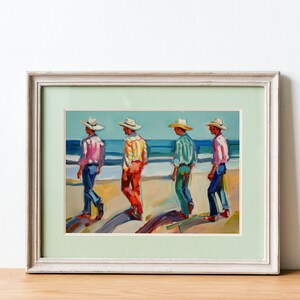 May include: Framed art print depicting four figures in hats and colorful shirts walking on a beach. The painting features a light blue sky and ocean, with the figures casting long shadows on the sand. The artwork is framed in a white wooden frame.
