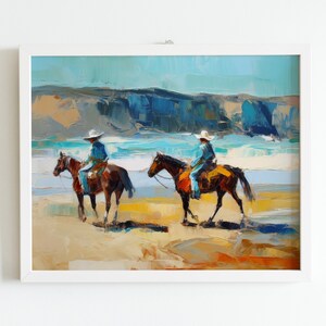 Peut inclure: Deux personnes &agrave; cheval se prom&egrave;nent sur une plage de sable avec une eau bleue et une falaise rocheuse en arri&egrave;re-plan. Les chevaux sont bruns et les cavaliers portent un jean bleu et un chapeau de cowboy blanc.