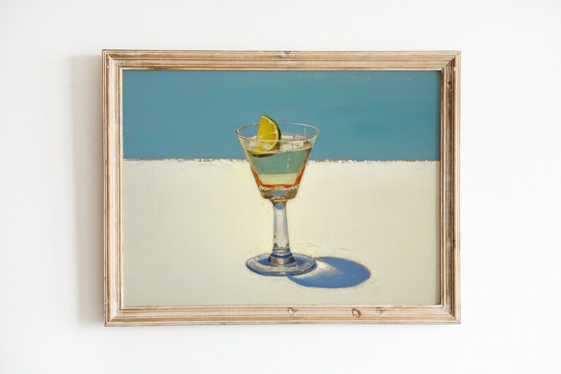 May include: A painting of a cocktail glass with a lime wedge on a white surface with a blue background.