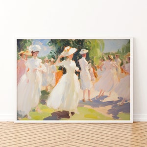 May include: An impressionistic painting of a group of people in white dresses and hats, set in a sunny outdoor scene. The artwork is framed in a white border and mounted on a wall above a wooden floor.