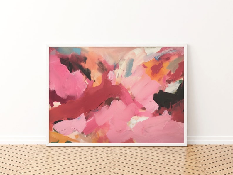 May include: Abstract art print in a white frame. The artwork features a vibrant mix of pink, red, orange, and black brushstrokes. The painting has a textured appearance, with visible layers of paint. The overall style is modern and expressive, suitable for home decor.