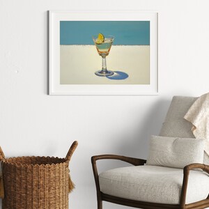 May include: A framed painting of a martini glass with a lime wedge on a white background with a blue sky in the background.