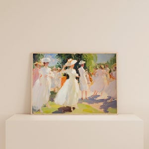 May include: A framed painting depicts a sunny outdoor scene with figures in white dresses and hats. The impressionistic artwork features a palette of soft greens, blues, and pinks, with visible brushstrokes. The figures appear to be dancing or strolling in a park.