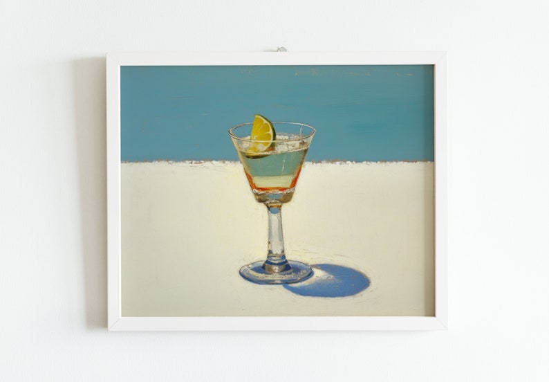 May include: A framed painting of a martini glass with a lime wedge on a white surface against a blue background.