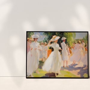 May include: A framed art print depicting a sunny outdoor scene. The painting features figures in white dresses and hats, with a vibrant green and yellow background. The artwork is displayed against a white wall.