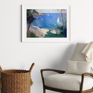 May include: A framed painting of a seascape with white sailboats on a blue body of water. The painting is framed in white and is hanging on a white wall.