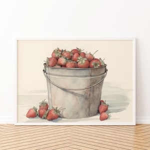 May include: A watercolor painting of a metal bucket filled with red strawberries. The bucket is sitting on a white surface with a few strawberries scattered around it.