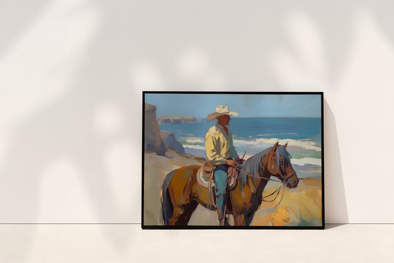 Pu&ograve; includere: Dipinto incorniciato raffigurante un cowboy a cavallo in riva al mare. Il cowboy indossa una camicia giallo chiaro e un cappello bianco. Il cavallo &egrave; marrone con una criniera grigia. Lo sfondo mostra un mare blu e scogliere.