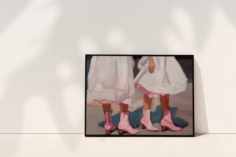 May include: Painting of two people wearing white dresses and pink boots. The painting is framed in black.