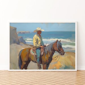 Pu&ograve; includere: Stampa di pittura a olio di un cowboy a cavallo, con vista sull'oceano. Il cowboy indossa un cappello bianco, una camicia gialla e jeans blu. Il cavallo &egrave; marrone con una criniera grigio-blu. L'opera &egrave; incorniciata.